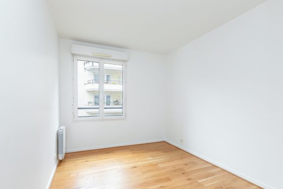 Chambre rénovée avec peinture intérieure claire et sol parquet